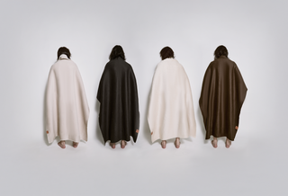 Four models shown from behind in cream, charcoal, ivory, and brown wool capes